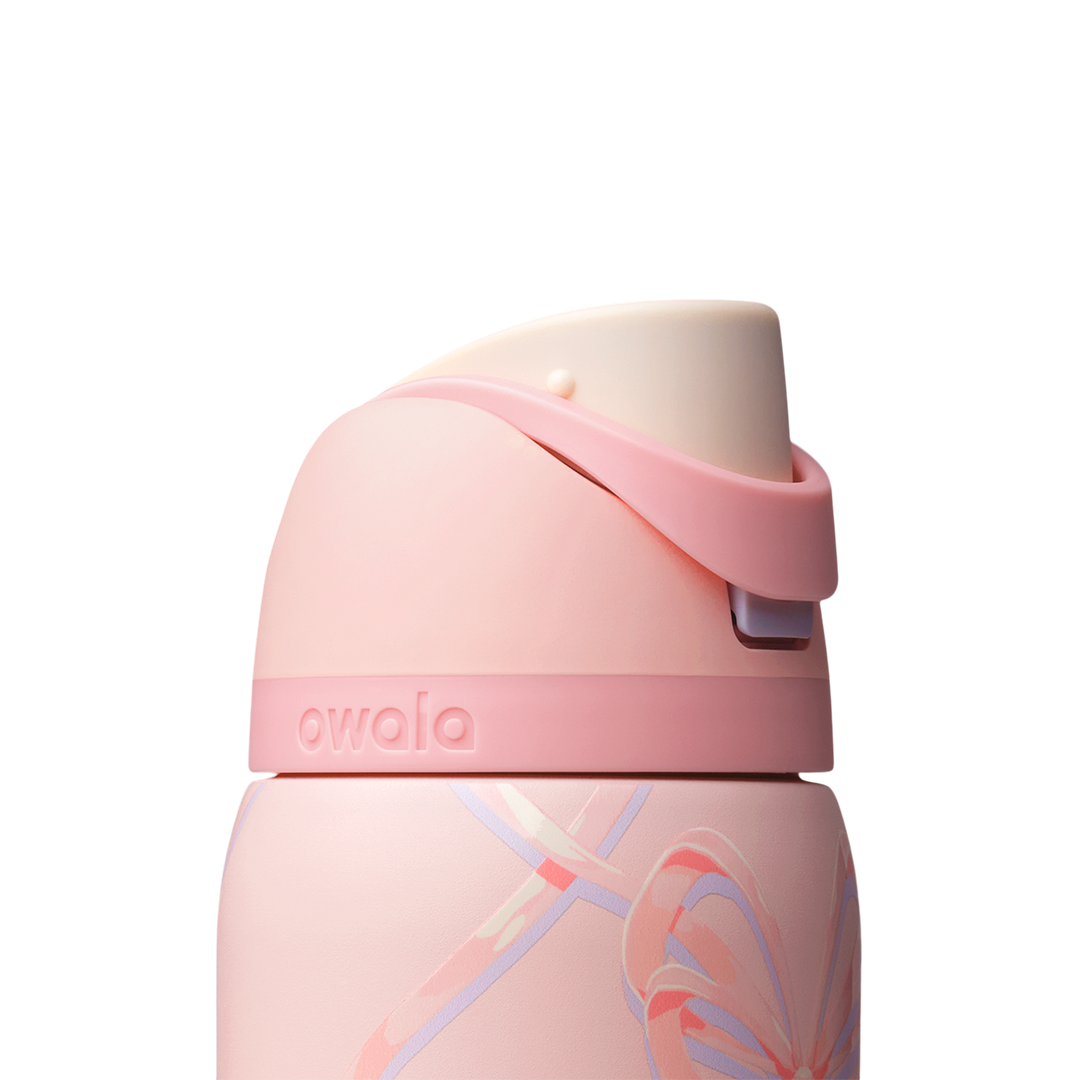 Owala FreeSip 32oz in Sugar Plum Fairy, close-up of pink flip cap with cream interior and pink carry loop folded over against the patterned body