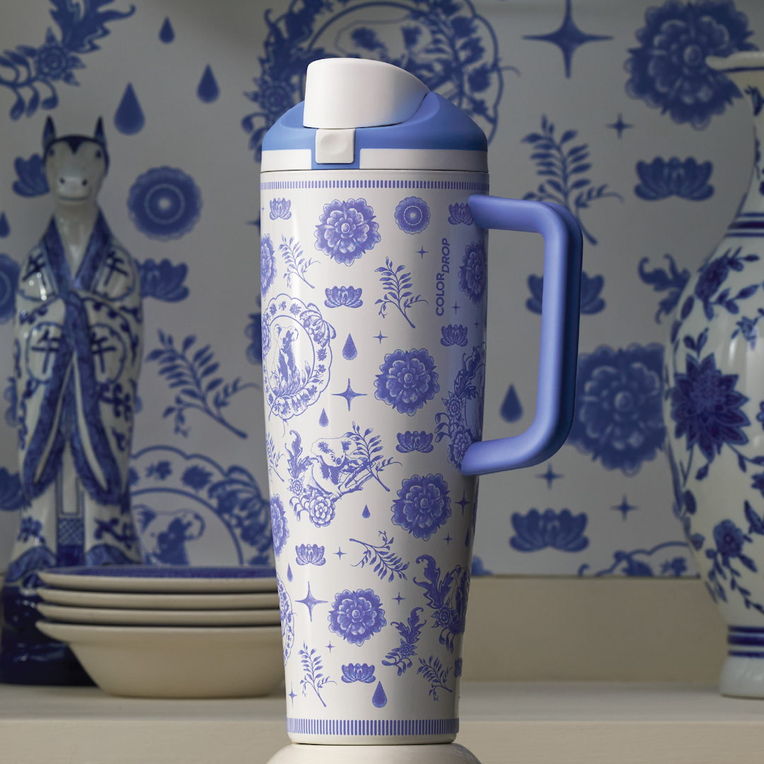 Owala 40oz Tumbler in a blue and white floral medallion pattern with a matching lavender straw and handle, displayed on a counter with patterned bowls and blue floral wallpaper