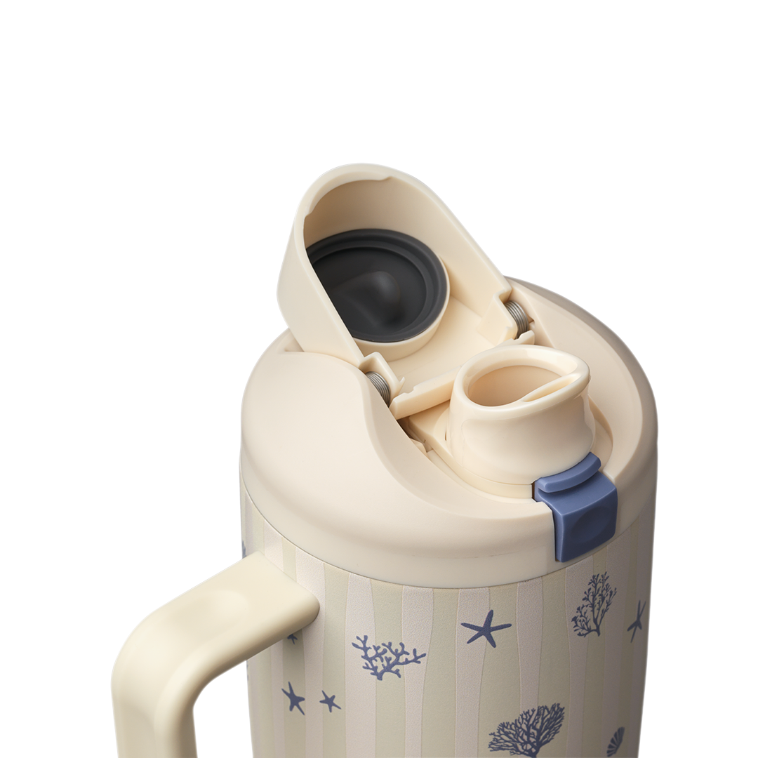 Owala FreeSip Tumbler 30oz in Coral Cabana, cream body with navy coral pattern, flip cap open showing cream FreeSip spout and navy push-button