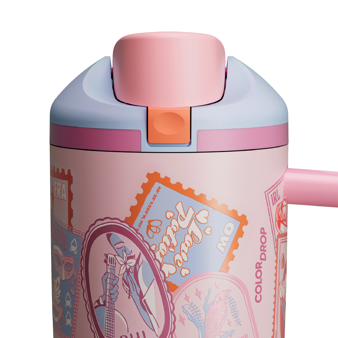 Owala FreeSip Tumbler in Sending Love, lid detail showing pink flip cap, pink push-button, and orange accent over postage-stamp-and-heart patterned body