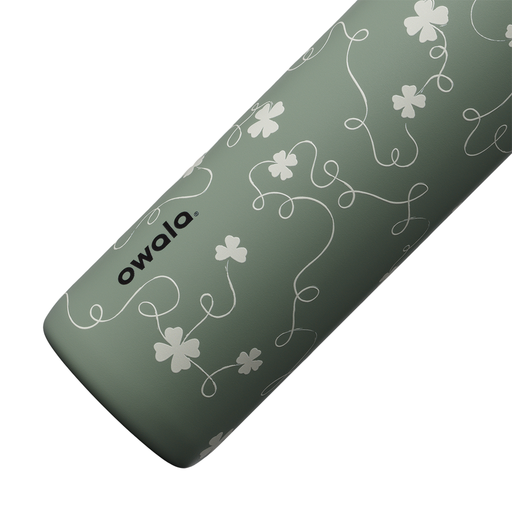 Owala FreeSip Twist 24oz in Clover Achiever, close-up of the sage green body showing the white clover and vine pattern and the Owala logo