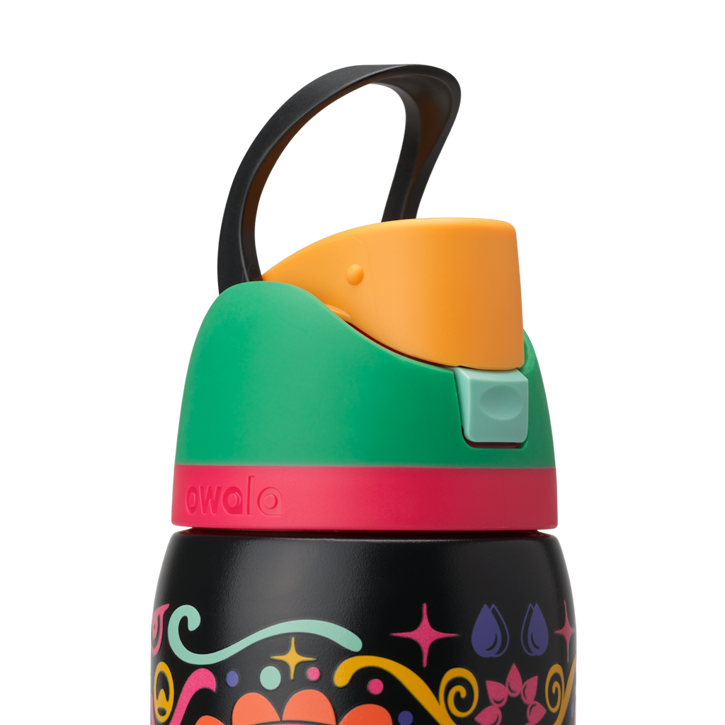 Owala FreeSip Sway 32oz in Sugar Skull, black carry loop raised above green flip cap with orange push-button and pink lid accent ring; glows in the dark