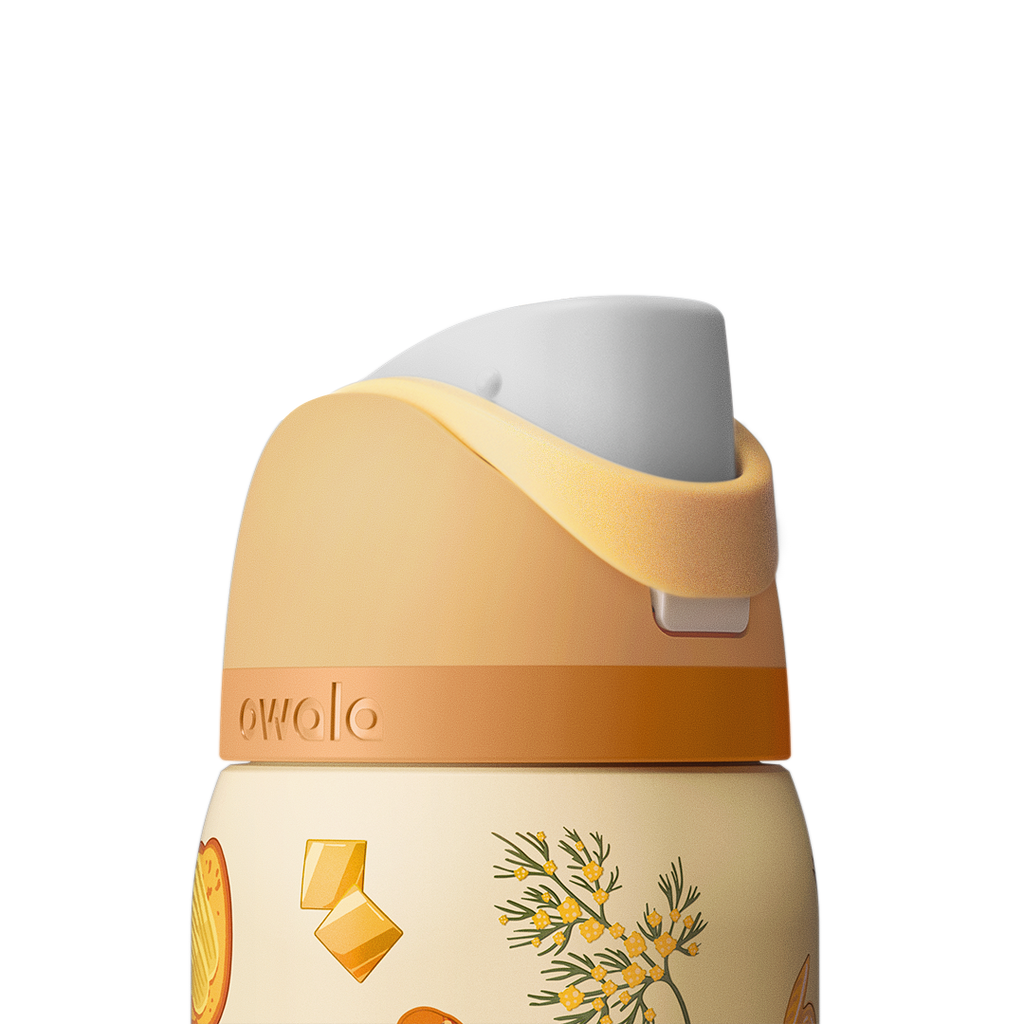 Owala FreeSip 32oz in Brunch Bunch, close-up of the peach flip cap and cream carry loop folded down over the lid