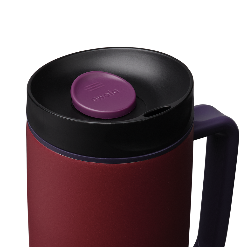 Owala SmoothSip Slider with Handle 24oz in Burgundy Bay, close-up of black lid with purple slider button and accent ring above deep crimson body with navy handle