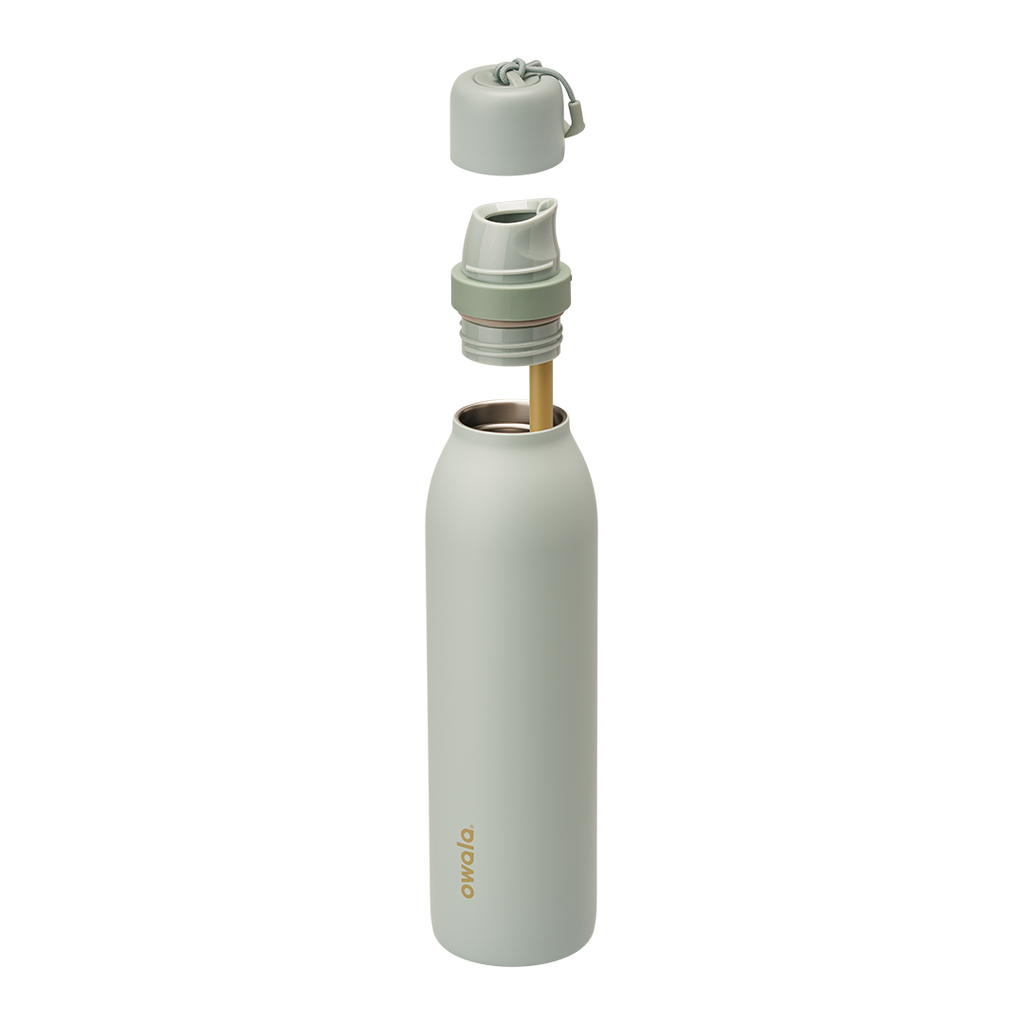 Owala FreeSip Twist 24oz in Summer Paradise, exploded view with sage green insulated stainless steel body and gold Owala logo, twist cap removed showing the FreeSip spout at the bottle opening, cap and FreeSip spout floating above with off-white carry string and carry string grip, gold-toned straw inside the body