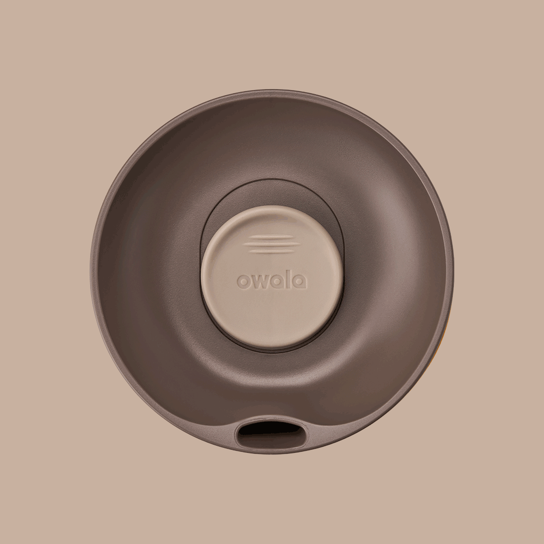 Owala SmoothSip Slider lid in Out of Sight, top-down rotating view of dark brown lid with beige slider button featuring embossed Owala logo, sip hole visible at bottom edge